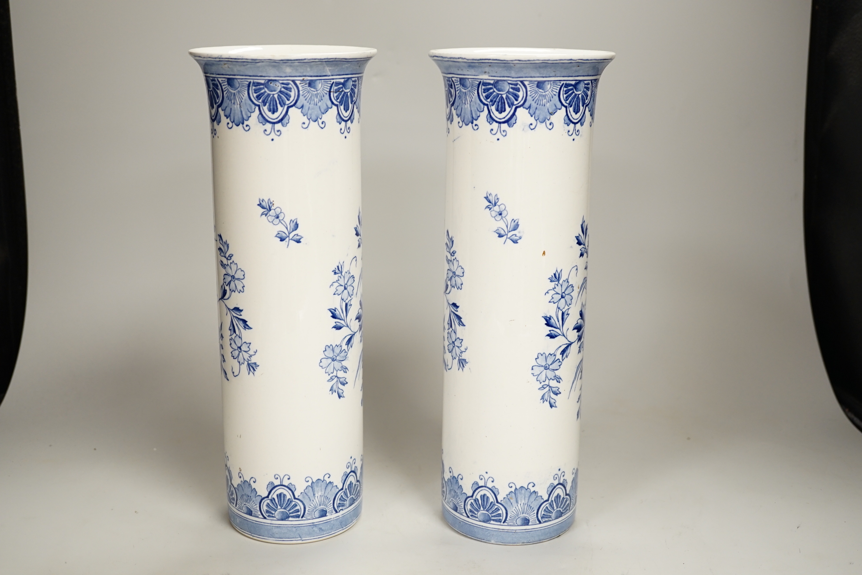 A pair of Delft blue and white cylindrical vases, each decorated with boats, 30cm high